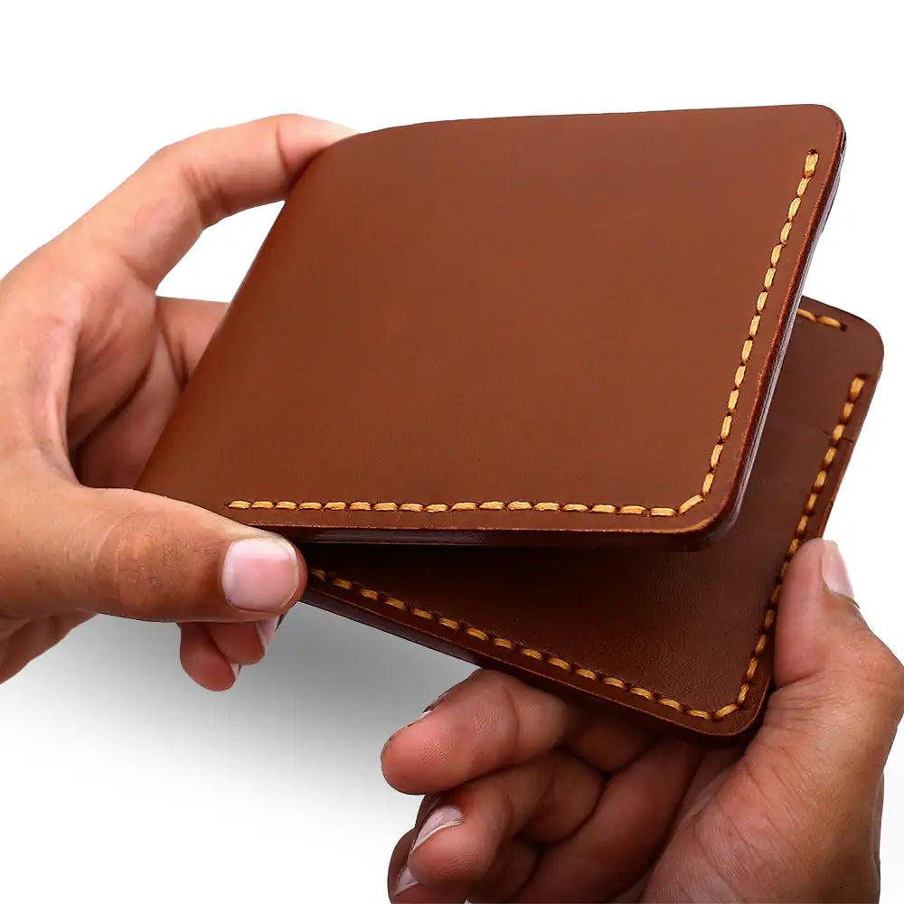 Lifestyle shot of a TASCONY men's leather wallet held in hand to illustrate the compact 11cm x 9cm ergonomic size and tactile full-grain finish.