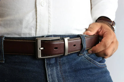 a person wearing a leather belt with blue jeans and white shirt