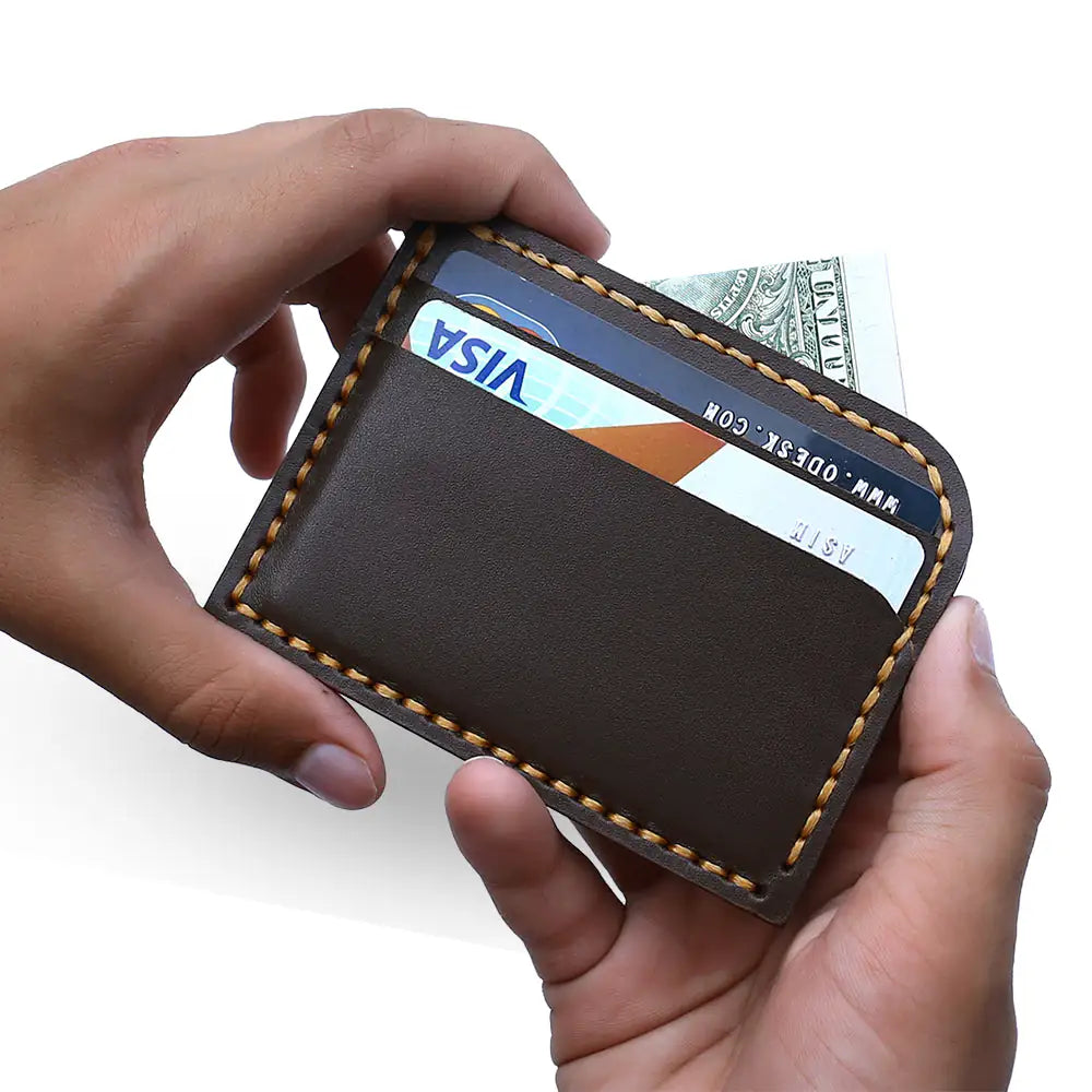 Dark brown leather cardholder with tan contrast stitching, displayed on a clean white background.
