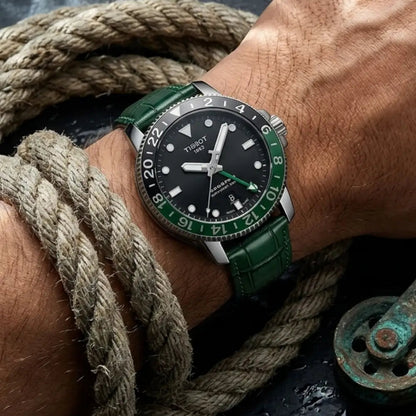 Tissot Seastar GMT watch fitted with a green crocodile leather watch strap, worn on the wrist beside rugged nautical rope and maritime hardware, showcasing premium craftsmanship and adventure-inspired style.