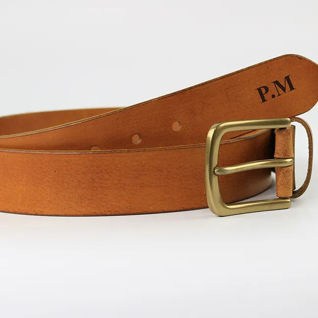 Cognac brown leather men’s belt with antique brass buckle and personalised initials shown on a clean white background.
