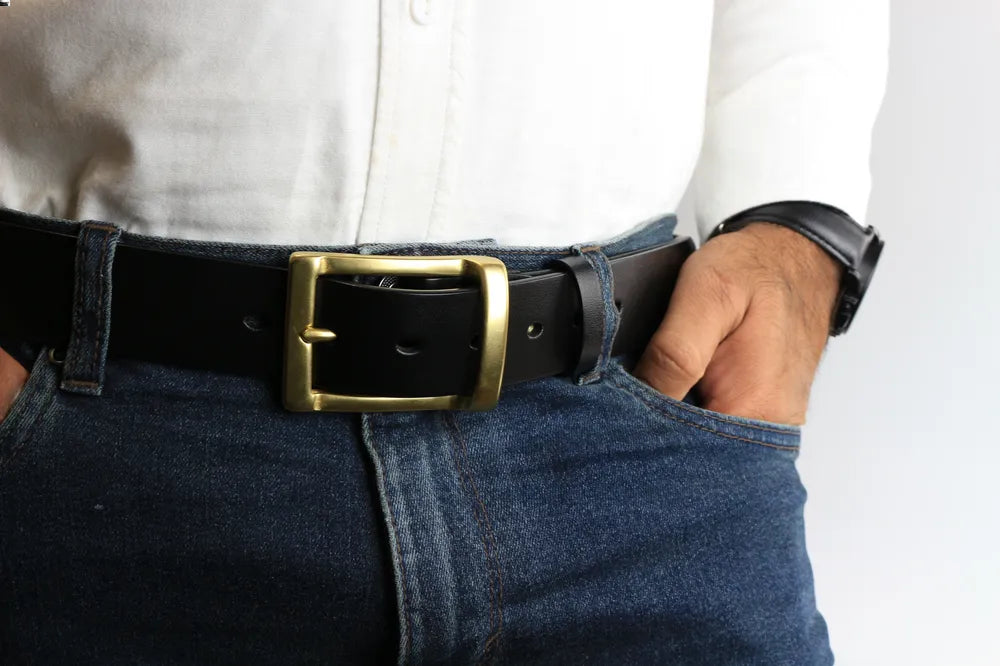 a person wearing a leather belt and jeans