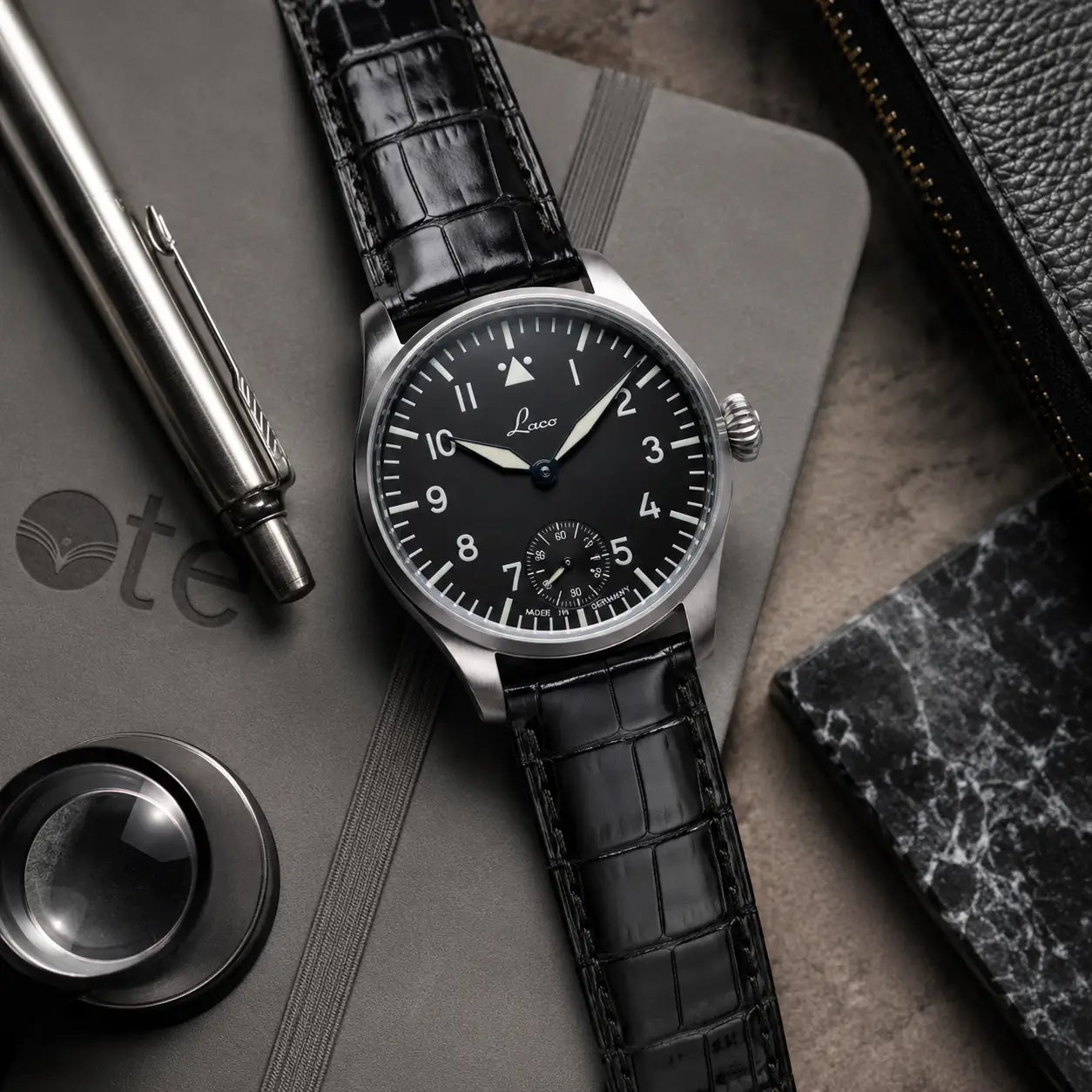 Genuine black crocodile leather watch band with tan underside lining, featuring a polished silver buckle on a classic white dial Laco timepiece.