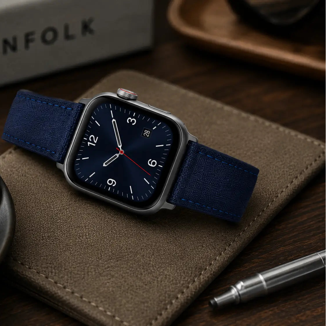 Premium lifestyle scene featuring a men’s smartwatch fitted with a navy blue textured watch strap. The watch is styled in a sophisticated desk setting with coffee, leather accessories, and warm ambient lighting, highlighting an elegant everyday-carry aesthetic.