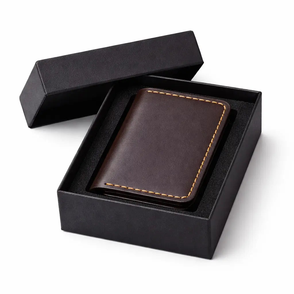 An open-flat view of a tan full-grain leather bifold cardholder against a white background, highlighting the interior's dual-pocket capacity with a stack of folded banknotes and a credit card secured by precision artisanal stitching.