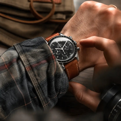 20mm Brown Italian Pueblo leather watch strap worn with Omega Speedmaster on wrist, handcrafted leather watch band with classic stitching and timeless design.