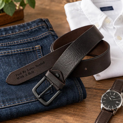 Black leather belt for men styled with blue jeans, wallet and watch in a casual flat lay