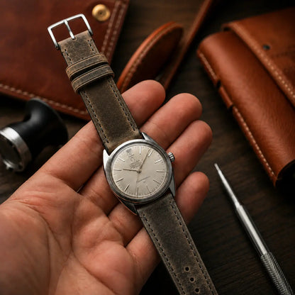 20mm dark grey vegetable tanned leather watch strap fitted to Omega Constellation vintage watch, handcrafted distressed leather watch band with classic stitching.