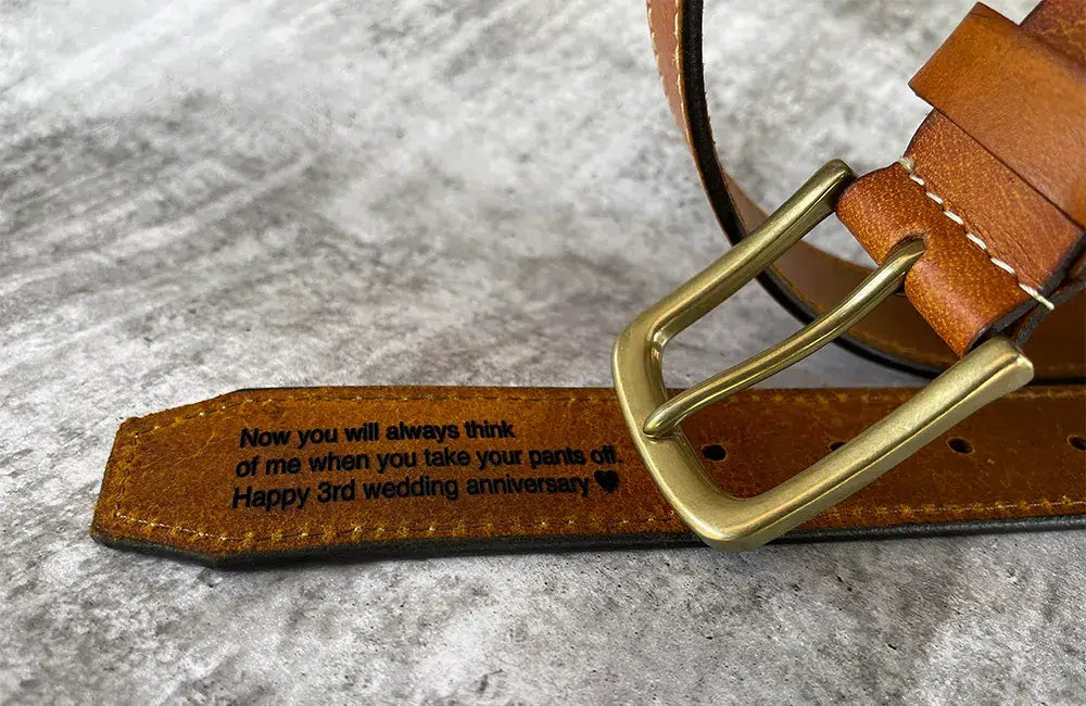 Close-up of brown leather men’s belt with antique brass buckle showing leather finish, stitching and product details.