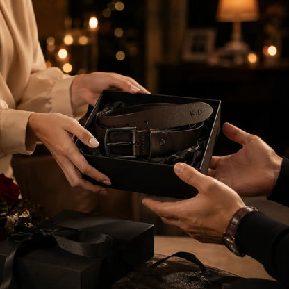 Black leather men’s belt presented as a gift in a premium lifestyle setting