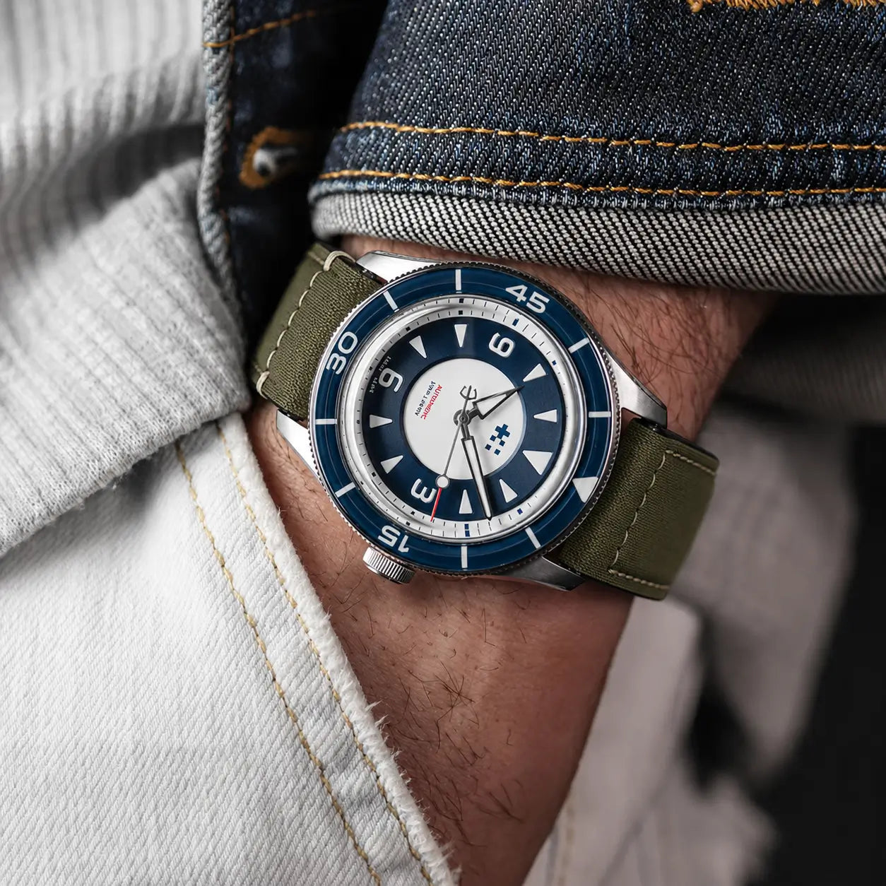 22mm olive green canvas watch strap on Aquastar dive watch worn on wrist, rugged military-style watch band with durable stitching and vintage outdoor appeal.