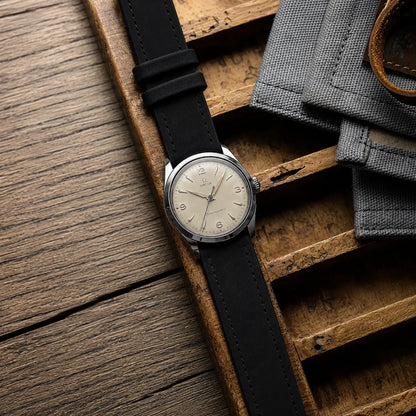 20mm black leather watch strap on vintage Omega Seamaster, minimalist handcrafted watch band with classic dress watch aesthetics.