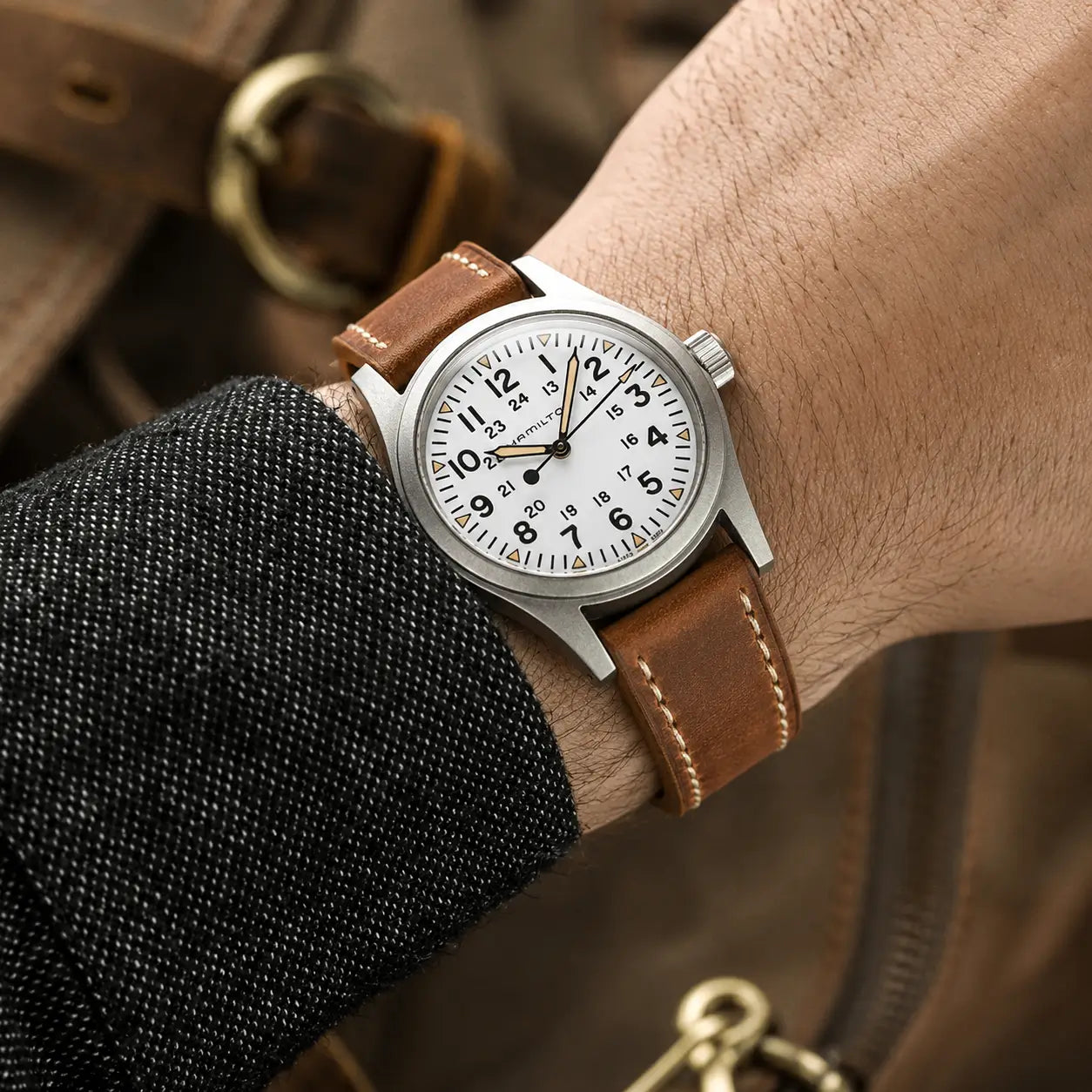 20mm Brown leather watch strap paired with Hamilton Khaki Field watch on wrist, handcrafted vintage-style watch band with contrast stitching.