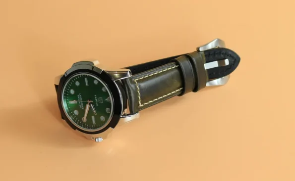Green Waxed Leather Watch Strap with a watch in a display