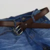 a brown belt on blue jeans