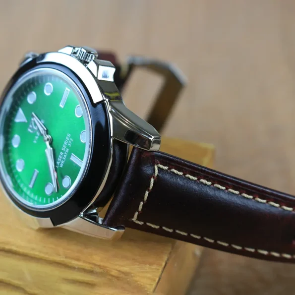 a close up of a watch with leather strap